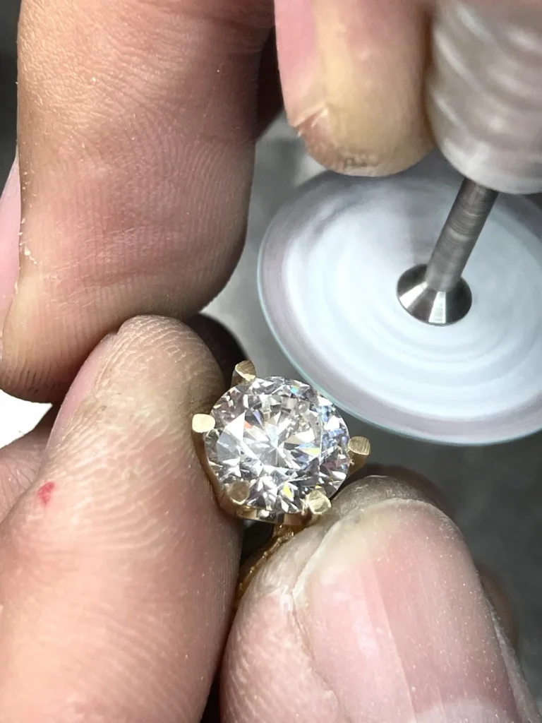 A close view of a diamond ring during setting work.
